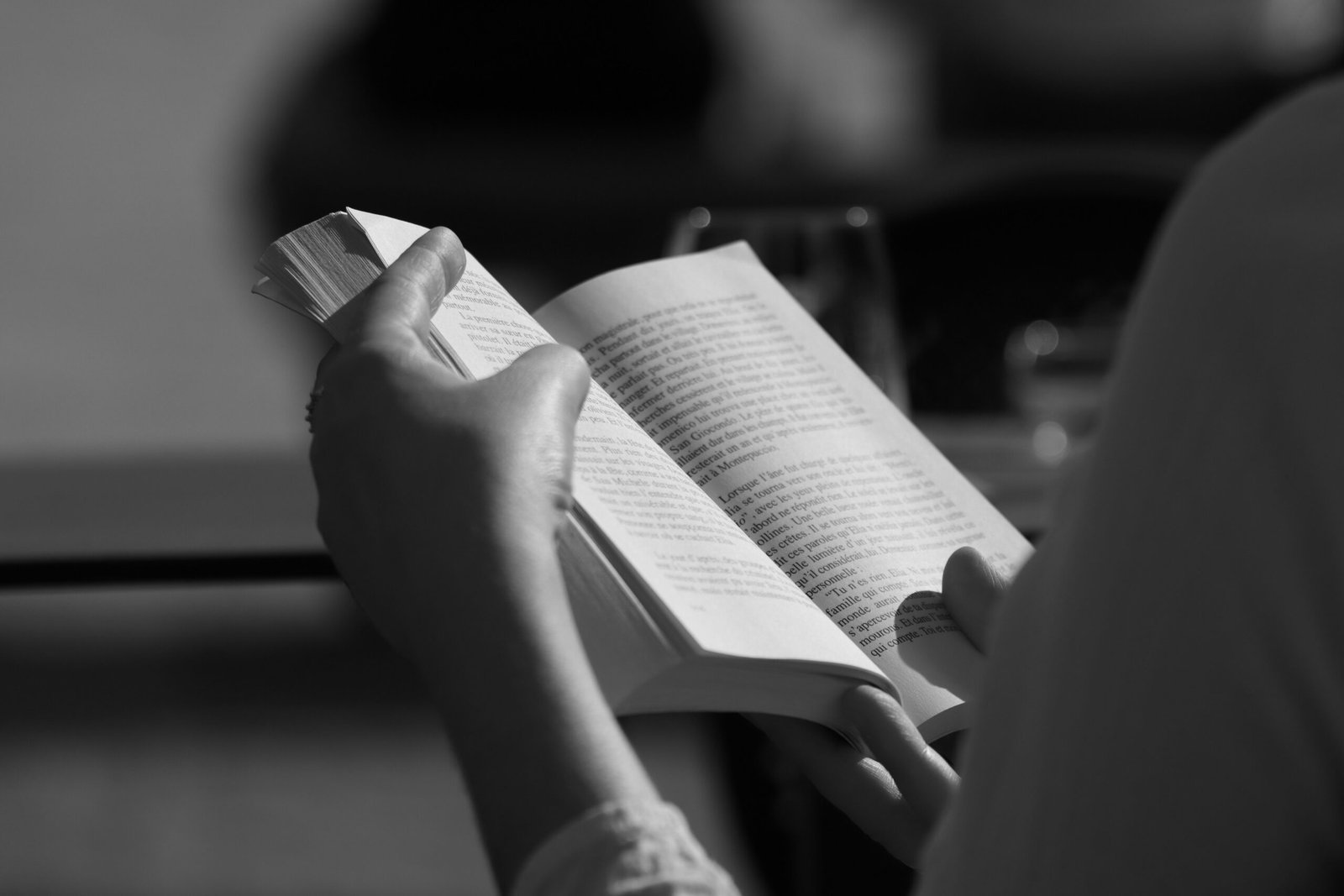Person engaged in reading a book, captured with selective focus in Florence.